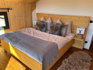 a bedroom with a large wooden bed with pillows at Bergchalet Stolzalpe 