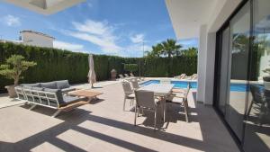 un patio con mesa y sillas junto a una piscina en Villa La Marina, en La Marina