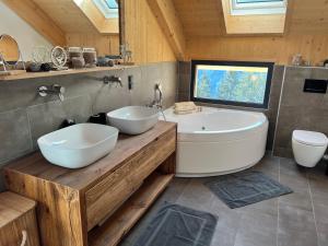 a bathroom with two white sinks and a tub at Bergchalet Stolzalpe 