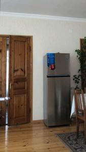 a kitchen with a refrigerator in a room with a door at Ekaterine Guest House in Stepantsminda
