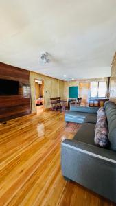 a living room with a couch and wooden floors at Gilligans Port Barton Beach Resort in San Vicente
