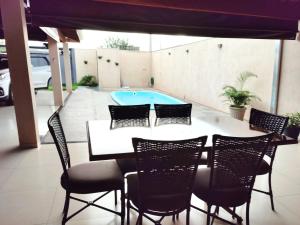 un patio con mesa y sillas y una piscina en Casa de Temporada Recanto Remanso, en Olímpia