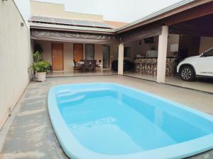 una piscina azul en el patio de una casa en Casa de Temporada Recanto Remanso, en Olímpia
