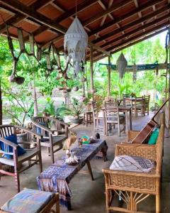 a patio with tables and chairs and a chandelier at Oro Beach Houses in Weetebula