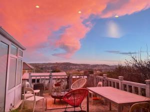 a patio with a table and chairs and a cloudy sky at Artist's home with views over Bath in Bath