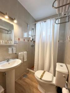 a bathroom with a white toilet and a sink at Beatriz Charming Hostal in Torremolinos