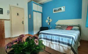 1 dormitorio con 1 cama con pared azul en Sweet Studio Lapa, en Río de Janeiro