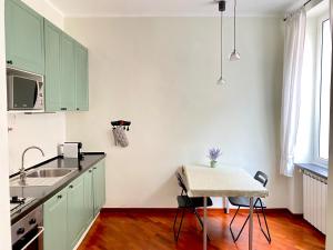 热那亚Tito's place的厨房配有绿色橱柜和桌子