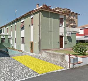 een gebouw met een gele mat op straat bij Appartamento Dolcefarniente in Lucrezia