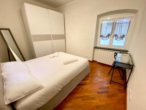 热那亚Tito's place的卧室里有一张白色的大床和一扇窗户