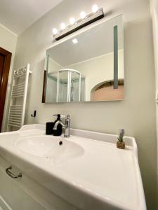 热那亚Tito's place的浴室里有白色洗手池和镜子