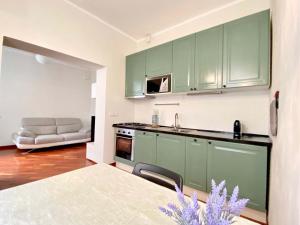 热那亚Tito's place的厨房配有绿色橱柜和沙发