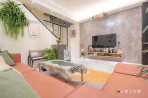 a living room with a couch and a tv at TING ZHU Homestay in Hualien City