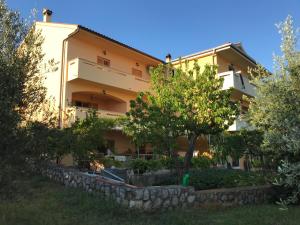 een gebouw met een stenen muur ervoor bij Apartment Dore in Krk