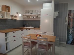 a kitchen with a wooden table with chairs and a sink at Apartament Nad Zatoką Puck in Puck
