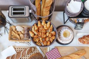 un tavolo con vari tipi di pane e prodotti da forno di Hôtel Restaurant Ritter'hoft a Morsbronn-les-Bains