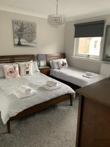 1 dormitorio con 2 camas y toallas. en Southfork Villa Guesthouse, en Callander