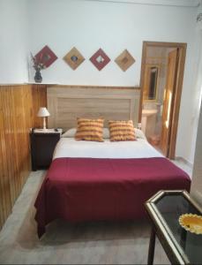 een slaapkamer met een groot bed en een rode deken bij Casa Hostal Olga - Castilla y León in Cofiñal