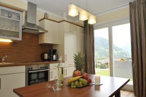 eine Küche mit einem Tisch und einer Obstschale darauf in der Unterkunft Villa Castelli in Schladming