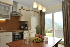 una cucina con un tavolo con una ciotola di frutta sopra di Villa Castelli a Schladming