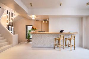 a kitchen with a bar with stools and a laptop on a counter at Skiathos Senses in Skiathos