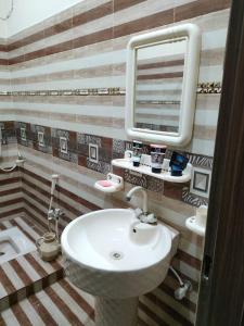 uma casa de banho com um lavatório e um espelho em Hotel Royal Luxury Multan em Multan