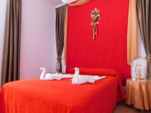 a red bed with two towels on it with a cross at Casa de la Abuela Pepa in Zafarraya