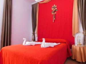 a red bed with two towels on it with a cross at Casa de la Abuela Pepa in Zafarraya