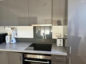 a kitchen with white cabinets and a counter top at YES Apartments in Crayford