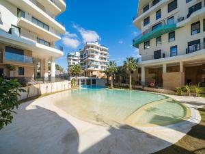 a swimming pool in front of some apartment buildings at Belvilla by OYO Casa Joyosa in Villajoyosa