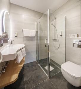 a bathroom with a shower and a sink and a toilet at Logis Hôtel Restaurant Ritter'Hoft in Morsbronn-les-Bains