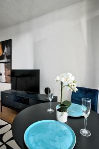 a dining room table with two glasses and a tv at Moderny byt, 300 m do centra mesta in Košice