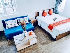 a hotel room with a bed and a couch at Delicate Serviced Apartment And Hotel in Da Nang