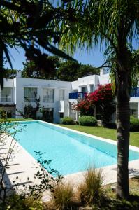 a swimming pool in front of a house at Kalá Hotel Boutique in Punta del Este