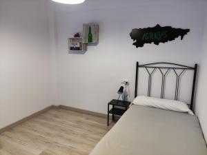 a bedroom with a bed and a sign on the wall at Apartamento Casa Aurelio in Gijón