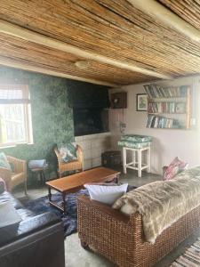 a living room with a couch and a table at Ou Werf Farm Cottage in Bredasdorp