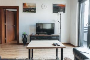 ein Wohnzimmer mit einem TV und einem Couchtisch in der Unterkunft Backspace Apartments in Vršac