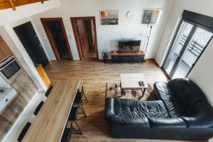 a living room with a leather couch and a table at Backspace Apartments in Vršac