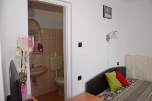 łazienka z toaletą i telewizor w pokoju w obiekcie Orchidea Apartman w Hévízie +37 zdjęć