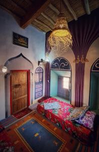 a bedroom with a bed and a chandelier at Hike and Chill Homestay in Tinerhir