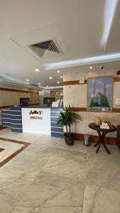 a lobby with a counter and a table in a room at Al Ayniah Hotel in Al Madinah