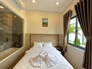 a bedroom with a bed with a heart decoration on it at VÂN TRANG GARDEN HOTEL 2 in Vĩnh Long