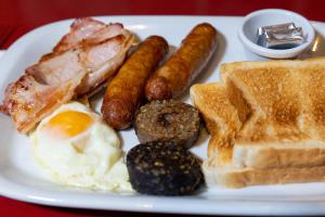 a plate of breakfast food with eggs sausage and toast at Behan's Horseshoe Bar & Restaurant in Listowel