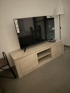 einen Flachbild-TV auf einem hölzernen Entertainment-Center in der Unterkunft شقة في الممشى الشارقة in Schardscha
