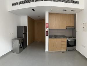 eine Küche mit einem Kühlschrank, einer Waschmaschine und einem Trockner in der Unterkunft شقة في الممشى الشارقة in Schardscha