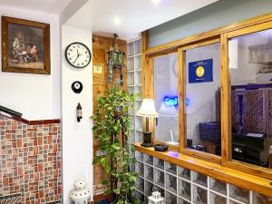 ein Zimmer mit einem Fenster und einer Uhr an der Wand in der Unterkunft Beatriz Charming Hostal in Torremolinos