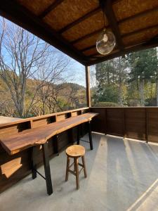 a large screened porch with a wooden table and a stool at かげやんのいえ　KAGEYAN NO IE in Tsu