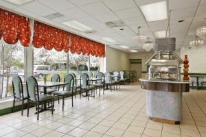 a restaurant with tables, chairs, and umbrellas at Ramada by Wyndham Roanoke in Roanoke