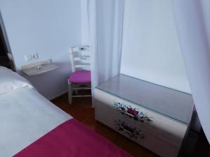 a bedroom with a bed and a window and a chair at Casa de la Abuela Pepa in Zafarraya
