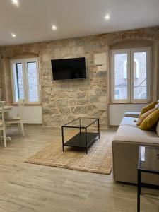 a living room with a couch and a stone wall at Cloe Apartment in Split